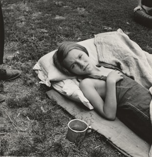 grayscale photography of girl lying near field