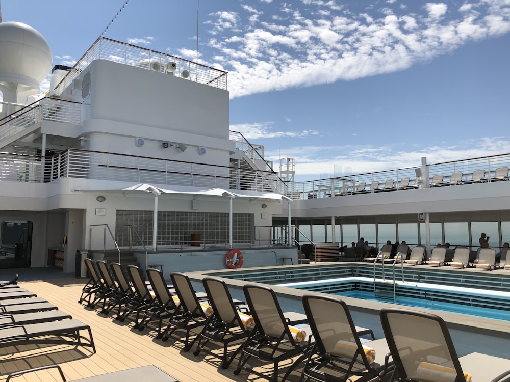 brown lounge chairs near big swimming pool