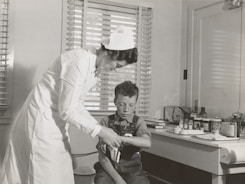 A caring nurse assisting a patient at home.