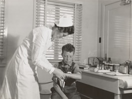 Close-up of Nurse Dolly carefully dressing a wound with gentle hands.