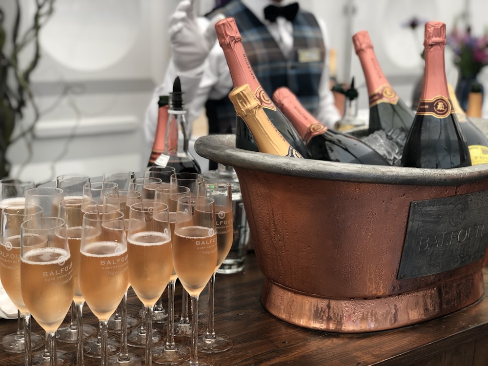 clear wine glasses beside gray steel bucket