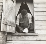 Worker using specialized tools to repair a window frame on a chilly day.