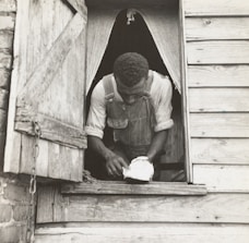Skilled worker repairing a wooden window frame in a historic building.