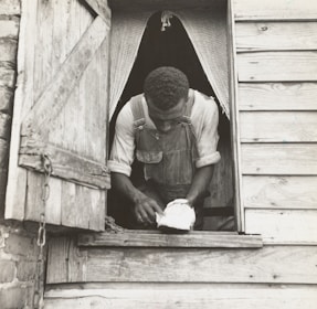 Skilled worker repairing a wooden window frame in a historic building.