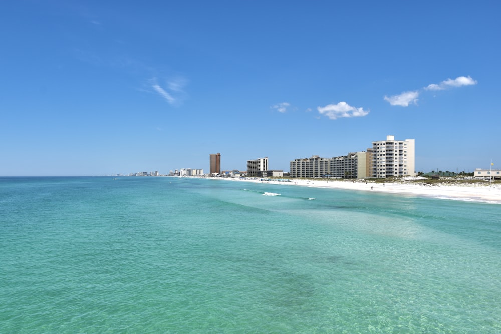 buildings near body of water under blue sky