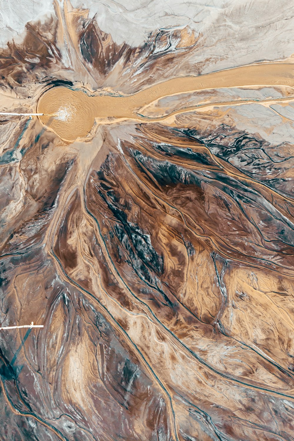 an aerial view of a desert with a brown circle in the center