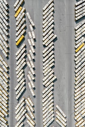 Fleet of well-maintained buses parked in front of a factory building.