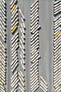 Fleet of well-maintained buses parked in front of a factory building.