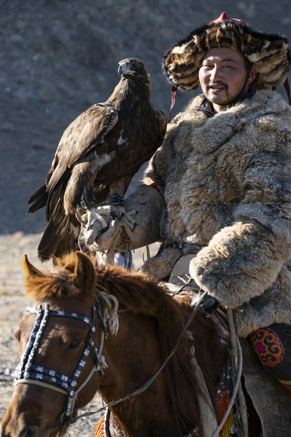 man riding on horse with eagle on arm