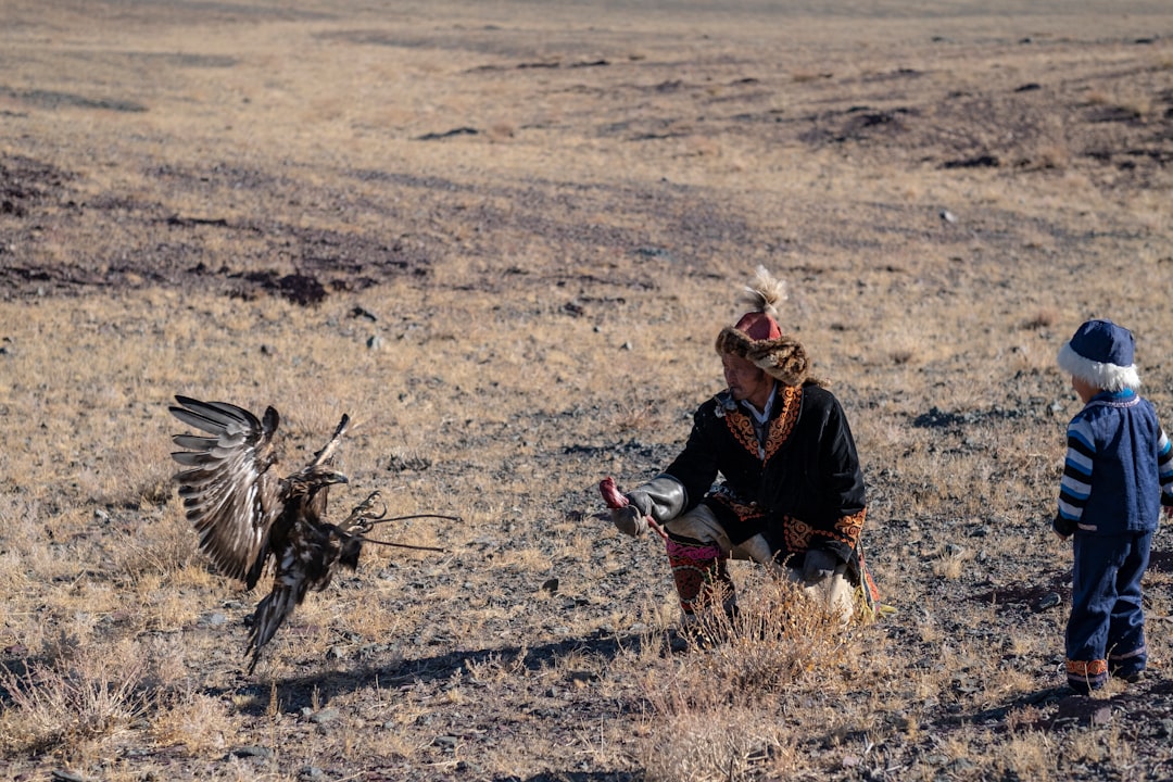 man and boy beside bird