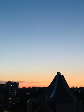 A sleek, minimalist cityscape at dusk with warm stone tones highlighting architectural lines.