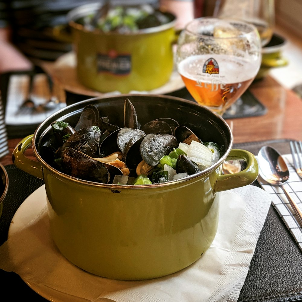 cooked mussels in pot on white textile