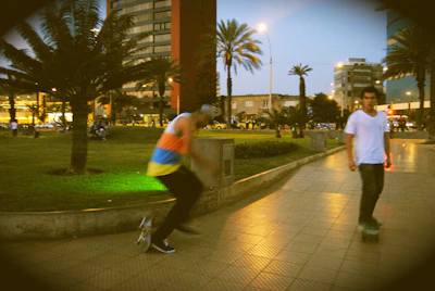 Evening scene with skaters gliding under city lights at a lively Tuesday meetup in a local park.