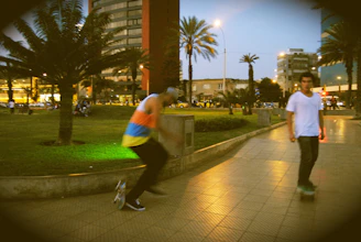 Evening scene with skaters gliding under city lights at a lively Tuesday meetup in a local park.