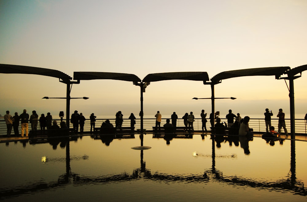 a group of people standing next to each other near a pool