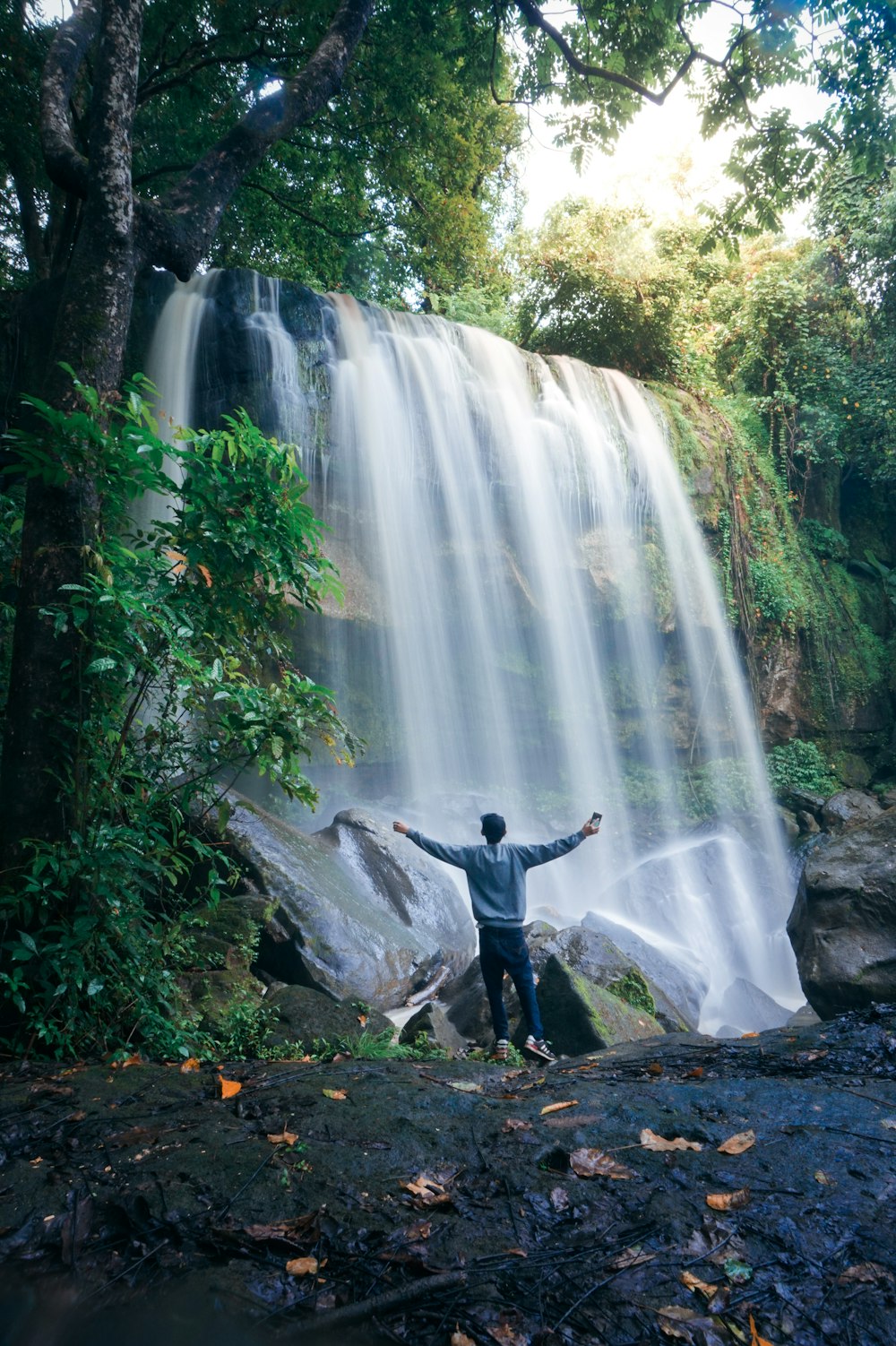 man standing in the foot on waterfall