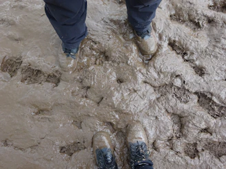 Close-up of firefighter's boots stepping through muddy terrain during a drill.