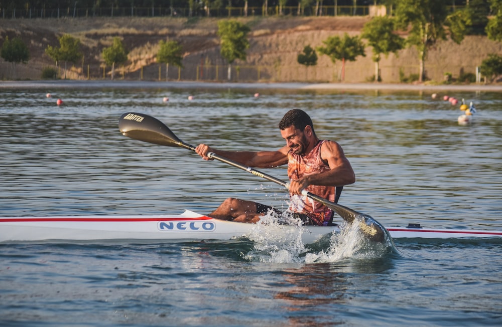 man riding kayak on sea