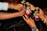 Several hands are reaching in to clink metallic cans with 'Wild Apple' labels on them. The scene suggests a celebratory toast among a group of people.