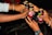 Several hands are reaching in to clink metallic cans with 'Wild Apple' labels on them. The scene suggests a celebratory toast among a group of people.