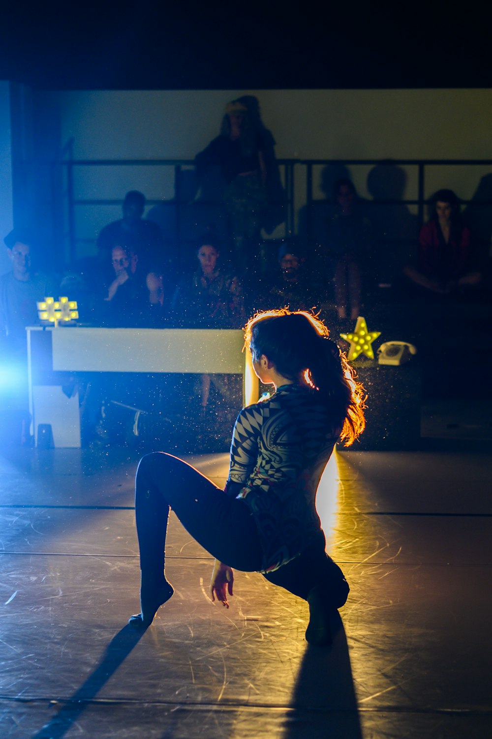 woman performing on stage near people sitting on bleachers