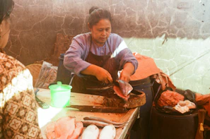 Hands expertly cleaning and filleting a fish with precision and care