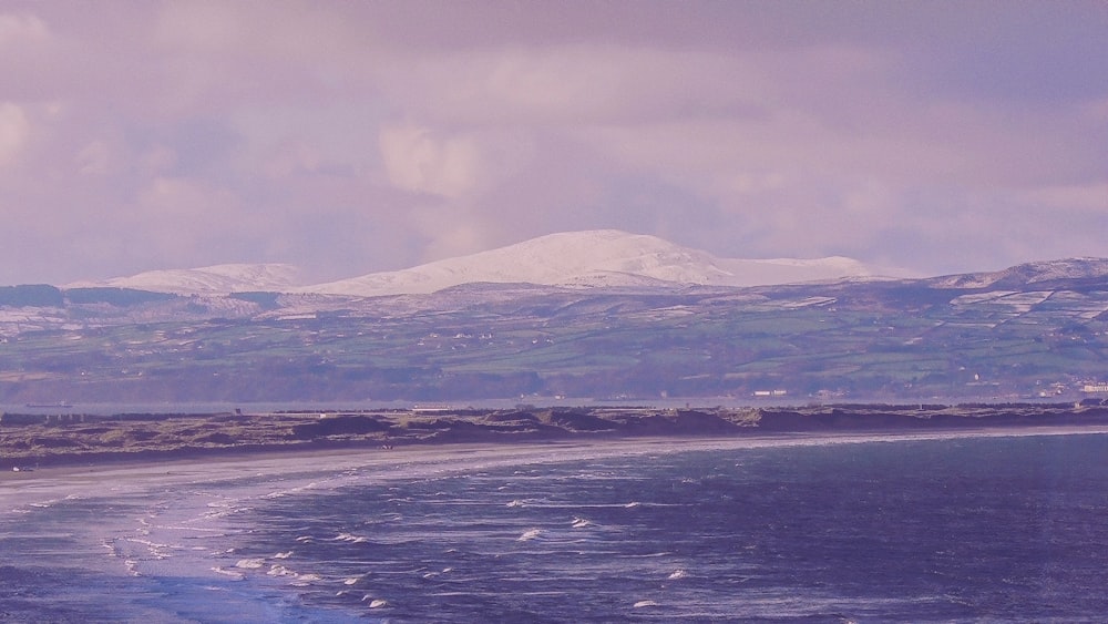 snow covered mountain and body of water