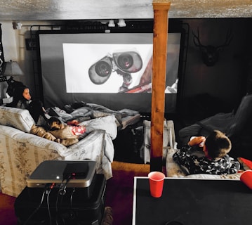 A cozy living room scene showing a family enjoying a movie together on a large HD TV screen.