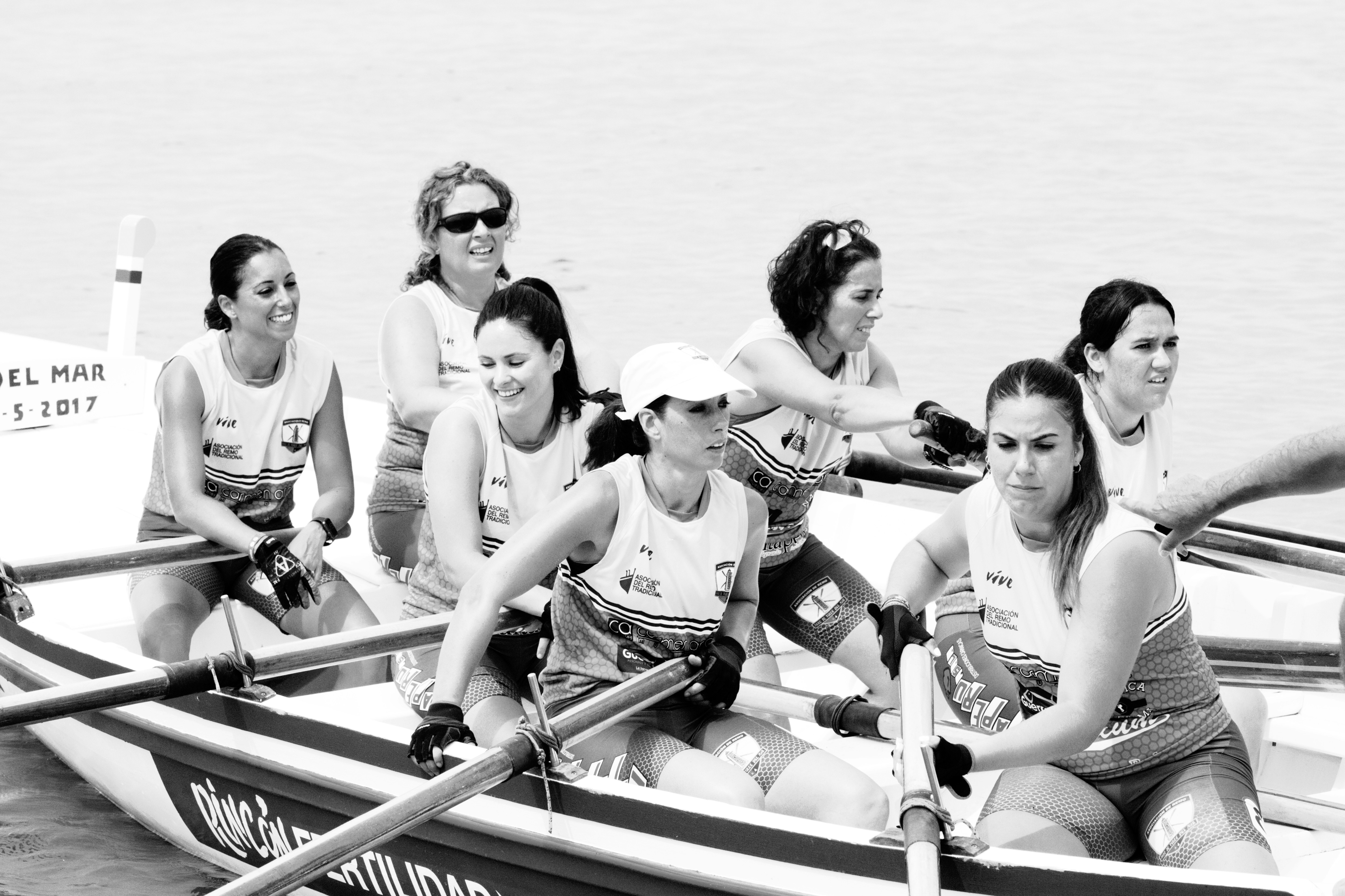 Equipo femenino del Club de Remo Faro de Torre del Mar recogiendo remos después de participar en una regata de jábegas en la playas de Pedregalejo (Málaga).