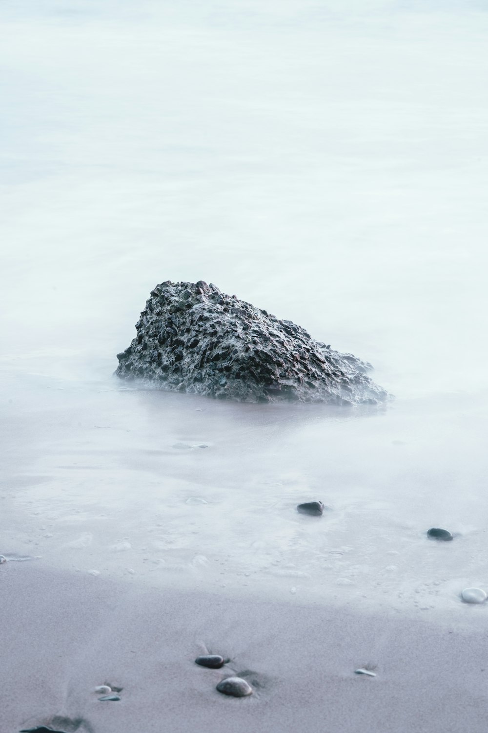 rock on sand shore during day