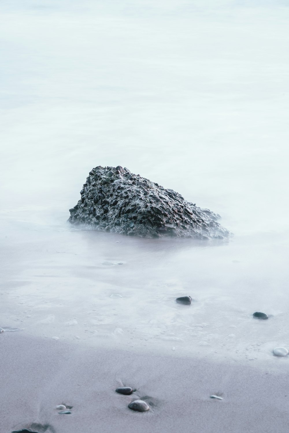 낮에는 모래 해안에 바위