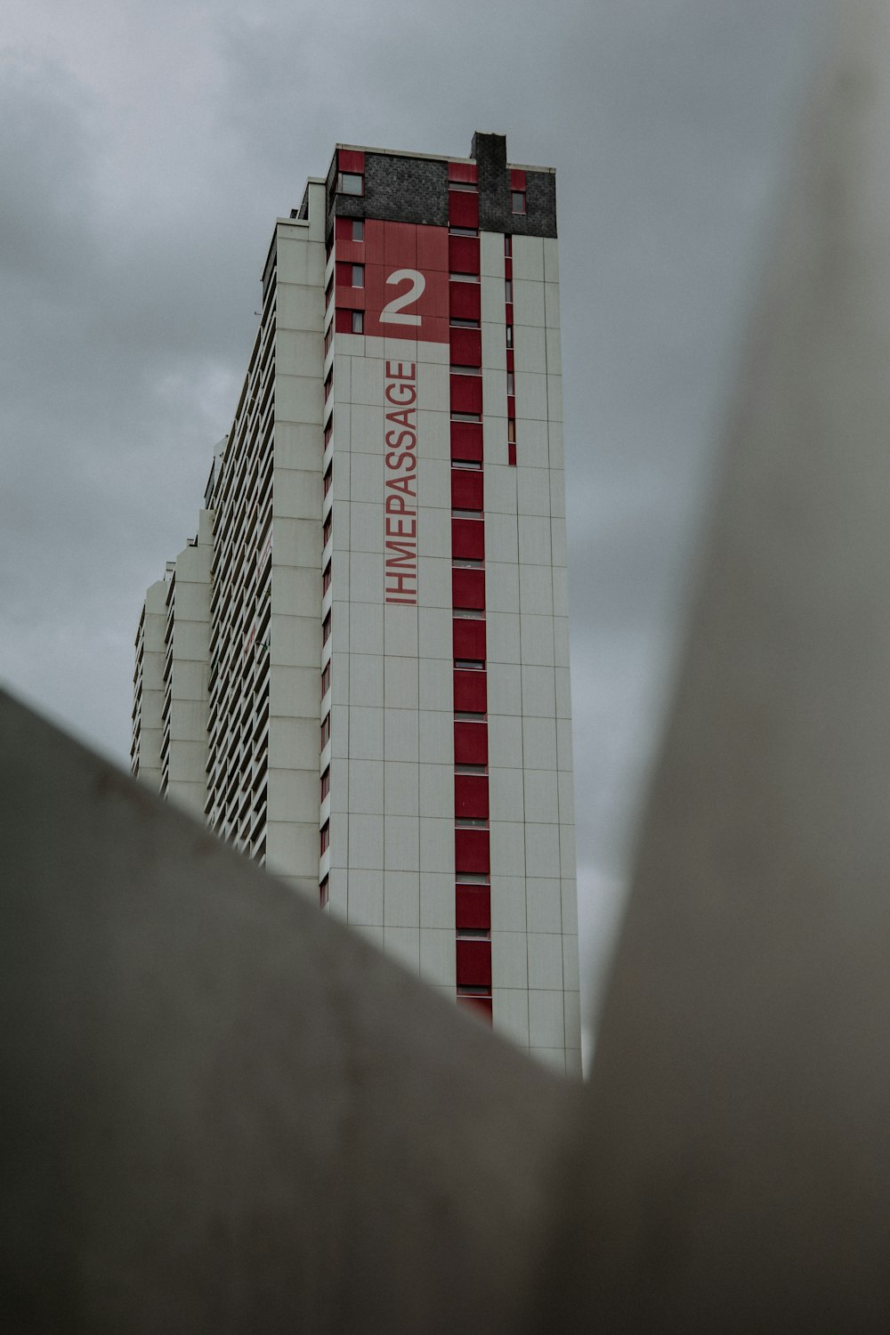 a tall white and red building next to a tall building