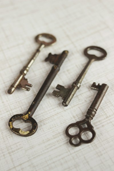 Four brass skeleton keys laid out on a plain surface, representing separate custody proofs for provider credentials and encryption keys