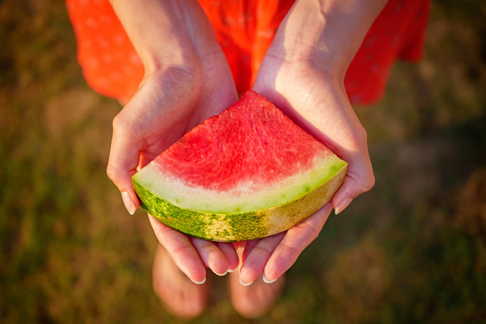 woman holding sliced watermelon