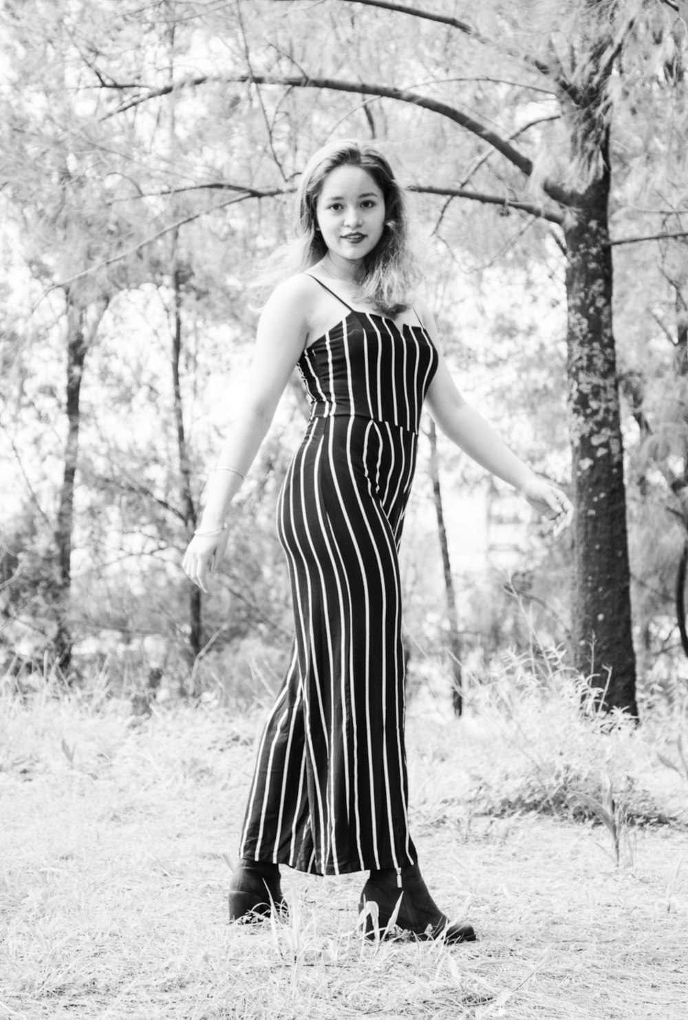 grayscale photography of woman standing near outdoor during daytime