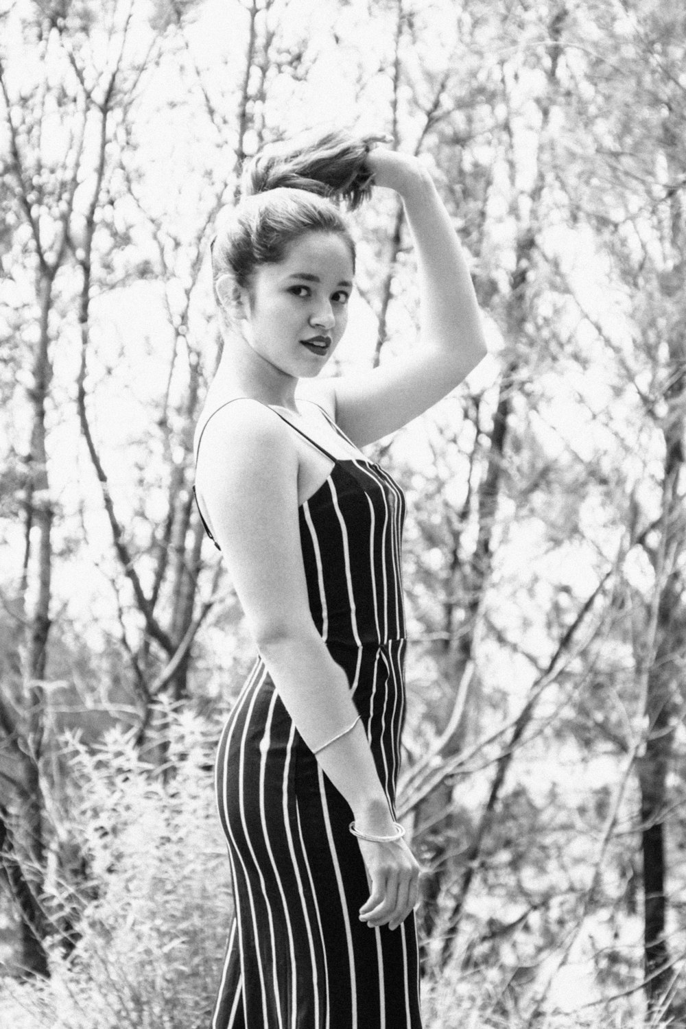 woman holding her hair in grayscale photo