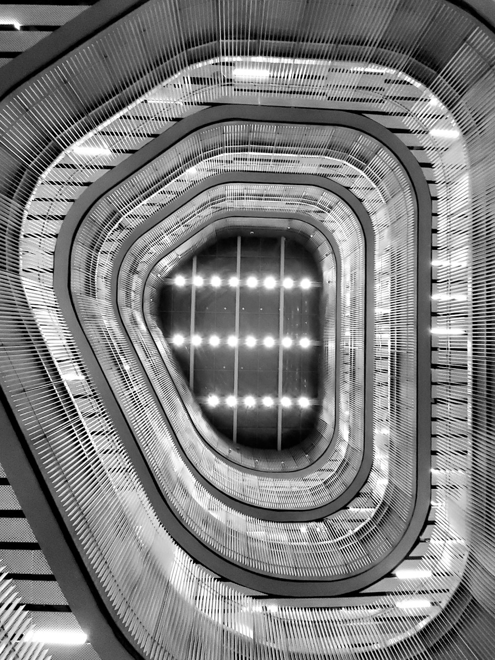 Photographie en niveaux de gris d’escaliers en colimaçon