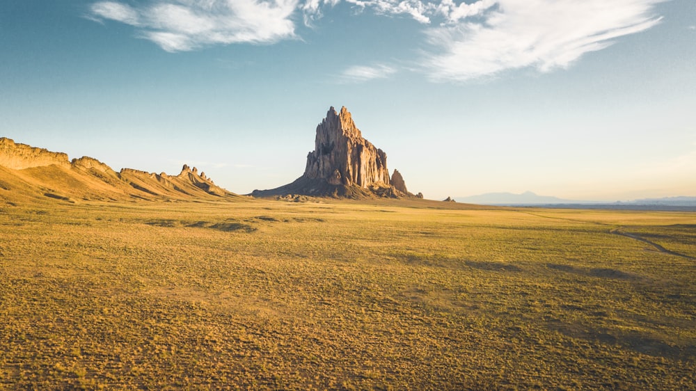 rock mountain under white clouds