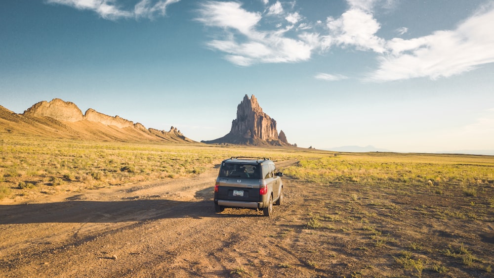 black SUV on dirt road at daytime