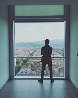 Professional cleaner tidying a modern apartment with mountain views.