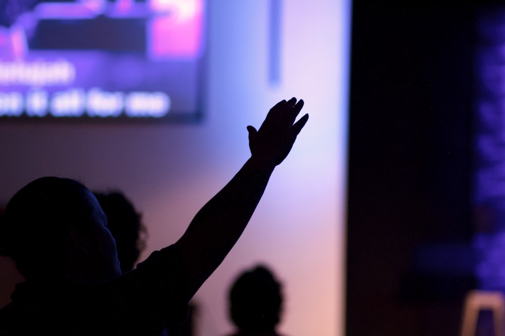 silhouette of man raising his right hand