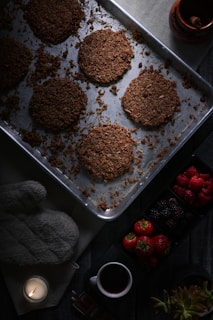 A warm kitchen scene showing a baker gently placing millet cookies into the oven.