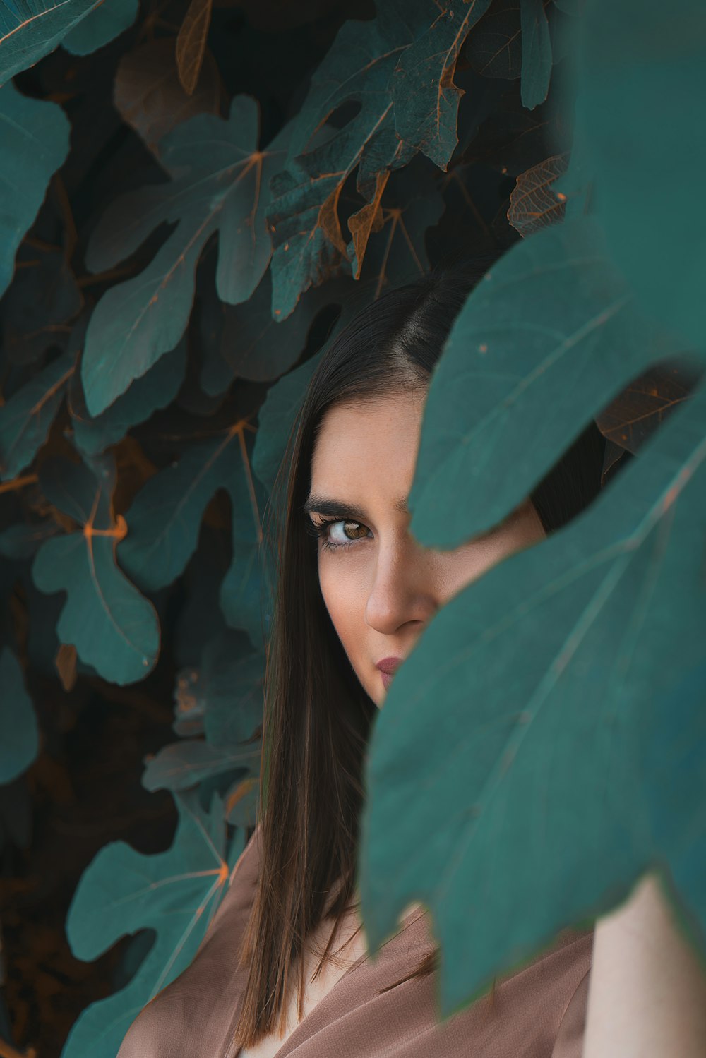 woman behind green leaves