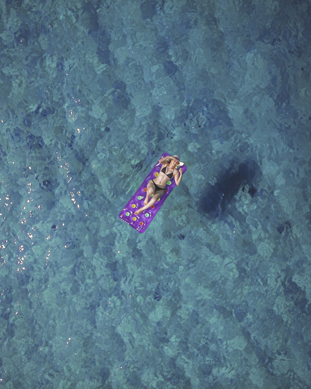 aerial photography of lying on purple floating bed on body of water during daytime