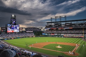 people in sports stadium watching baseball game