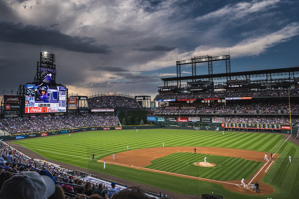 people in sports stadium watching baseball game