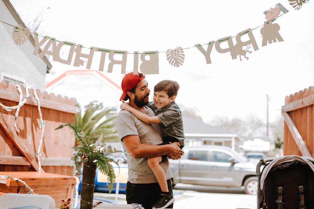 man carrying child during daytime