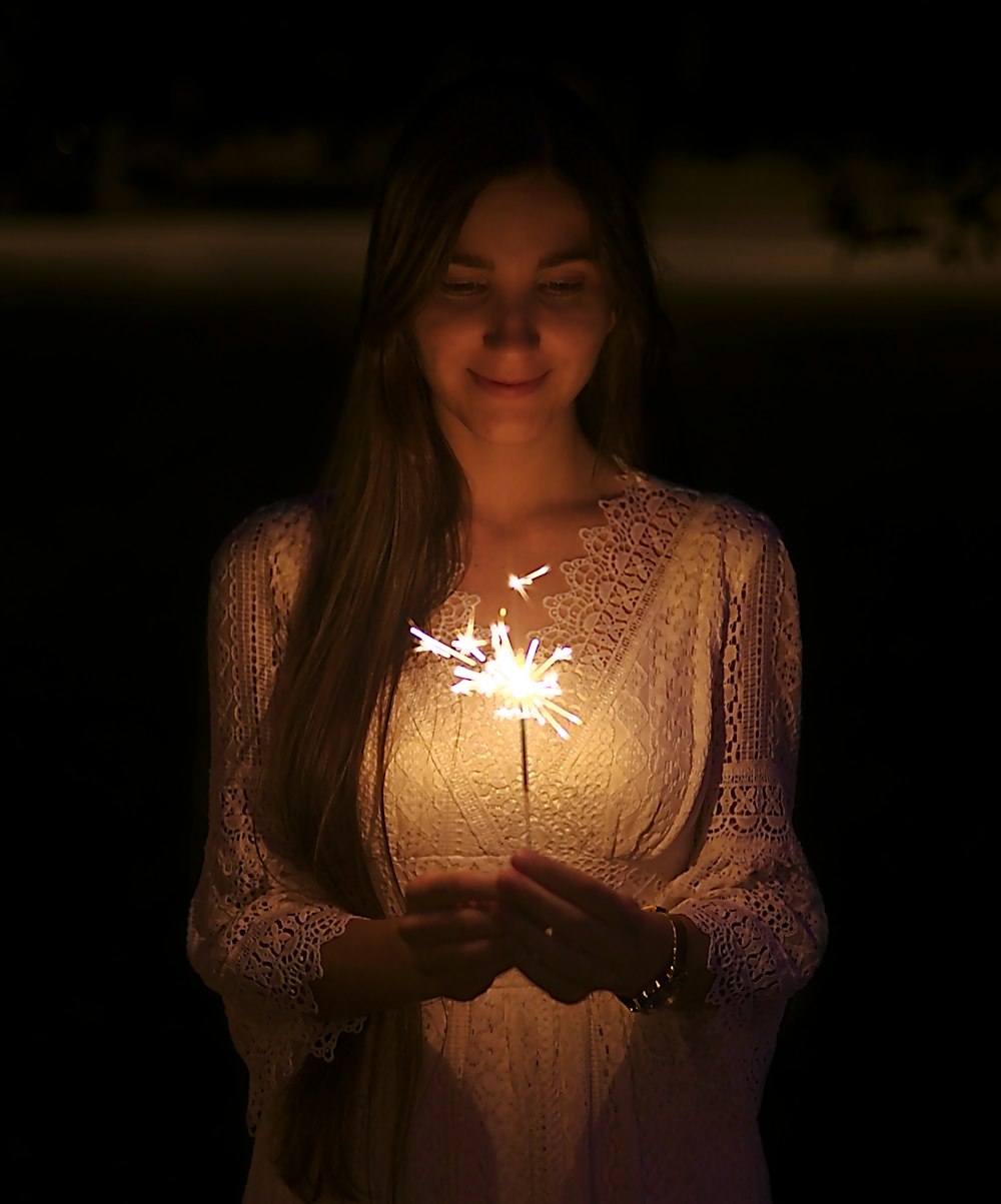 smiling woman wearing lighted sparkler