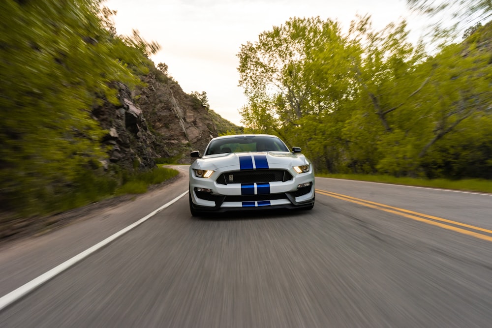 time lapse photography of running white and blue vehicle on road during daytime