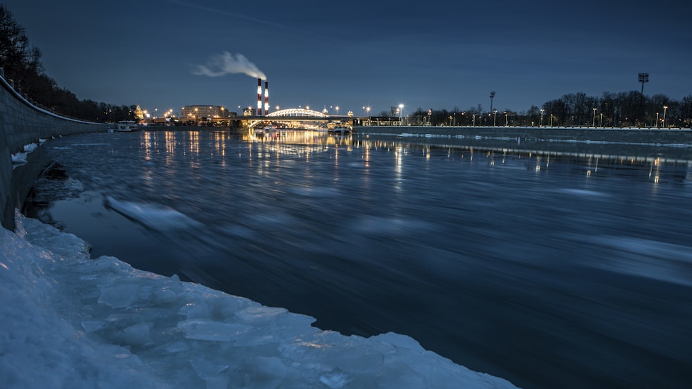 Fotografía de paisaje de paisaje urbano cerca del cuerpo de agua durante la noche